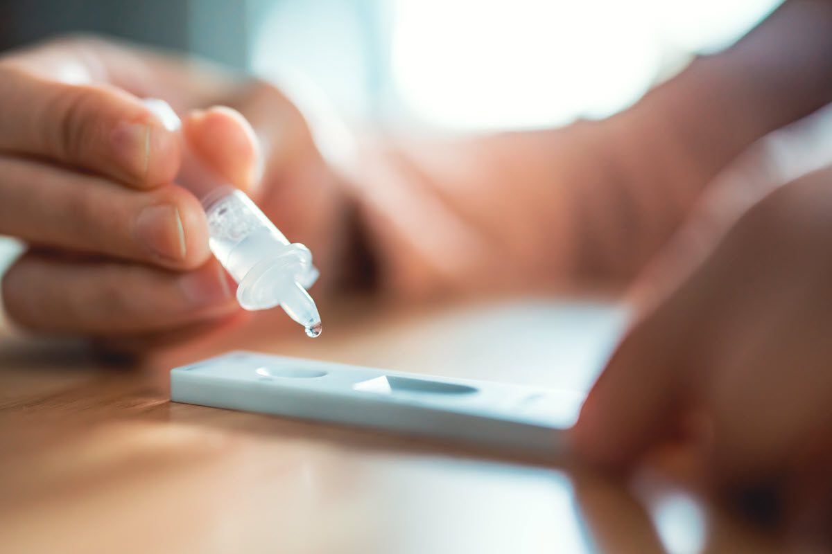 Close up of person's hands doing at home covid test